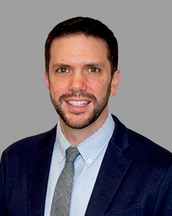 a man in a suit and tie is smiling for the camera