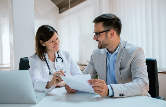 a doctor and consultant are looking at a piece of paper