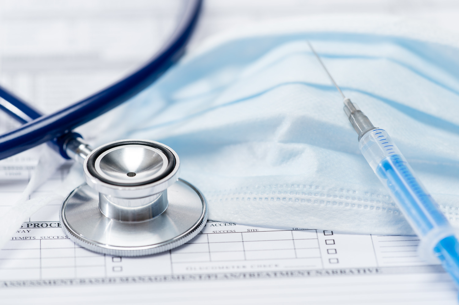 a stethoscope and syringe on top of a medical form